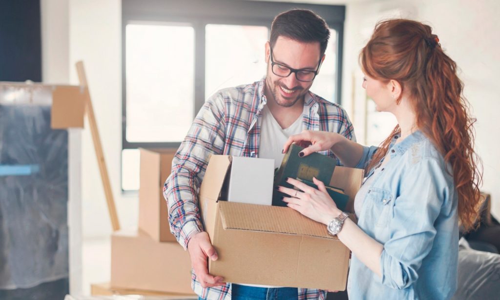 pareja embalando objetos en cajas de cartón corrugado